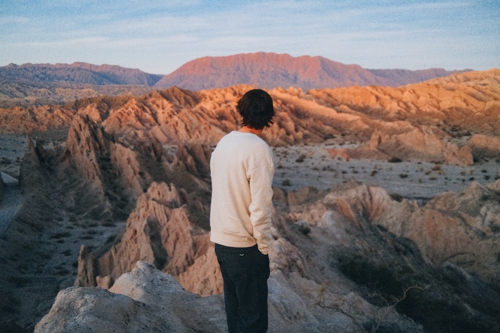 Eine Person, die auf einem Felsen steht und einen Canyon betrachtet