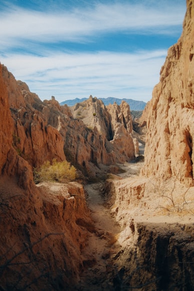 View of natural rock landscape formations making a valley ending in a road crossing through with a blue sky.