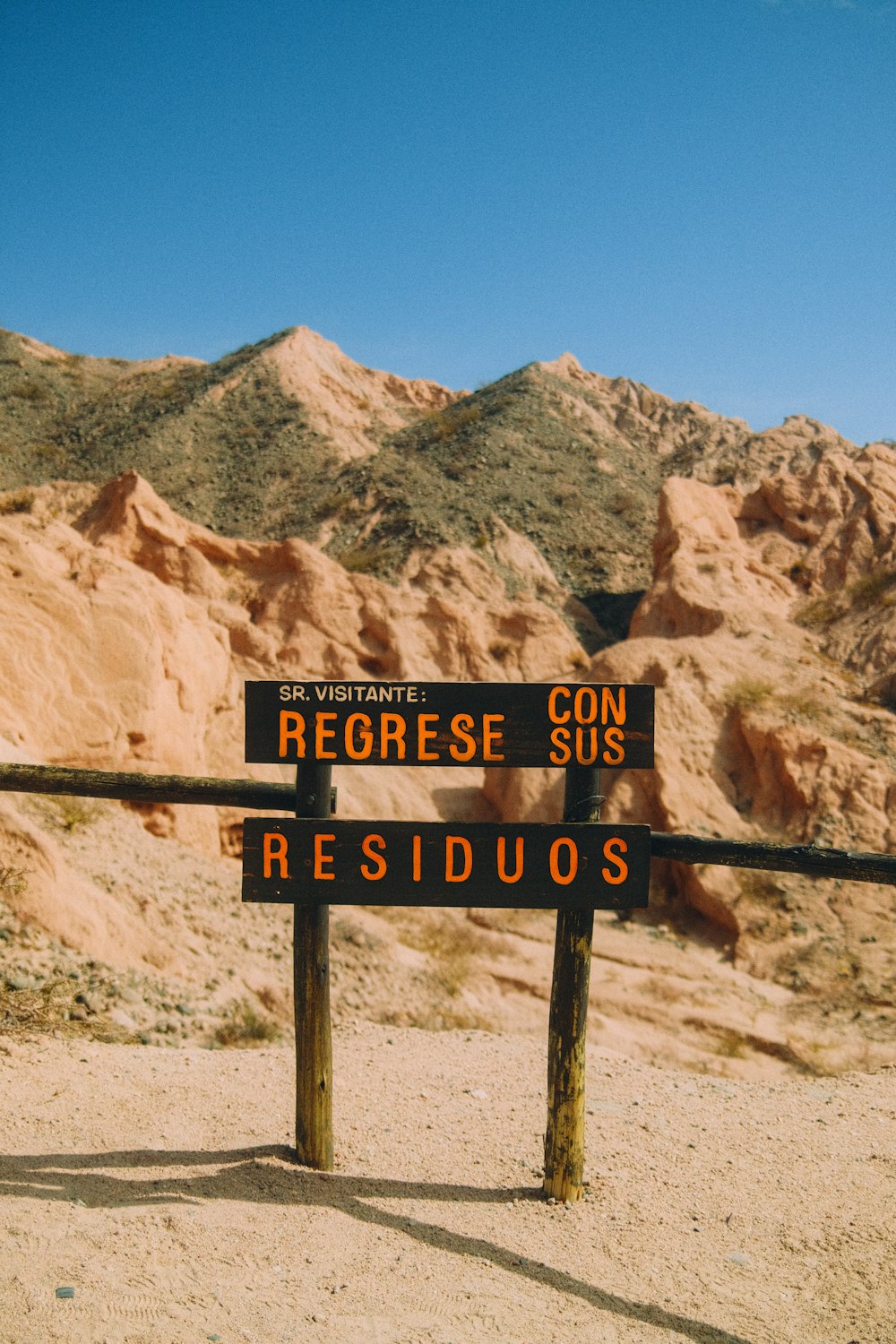 a sign in front of a rocky mountain