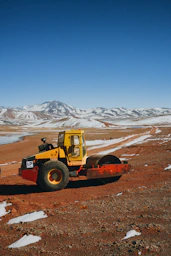 a yellow tractor on a dirt road