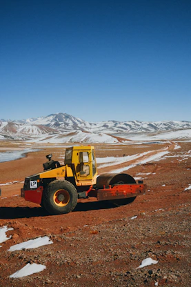 a yellow tractor on a dirt road
