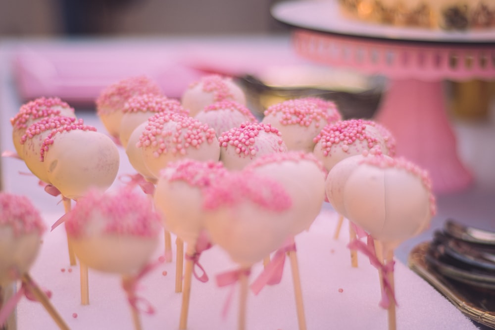 a group of pink and white cupcakes with frosting