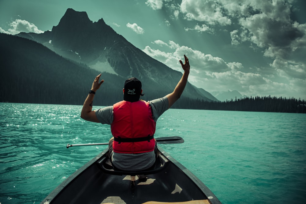 a man in a boat with his arms raised