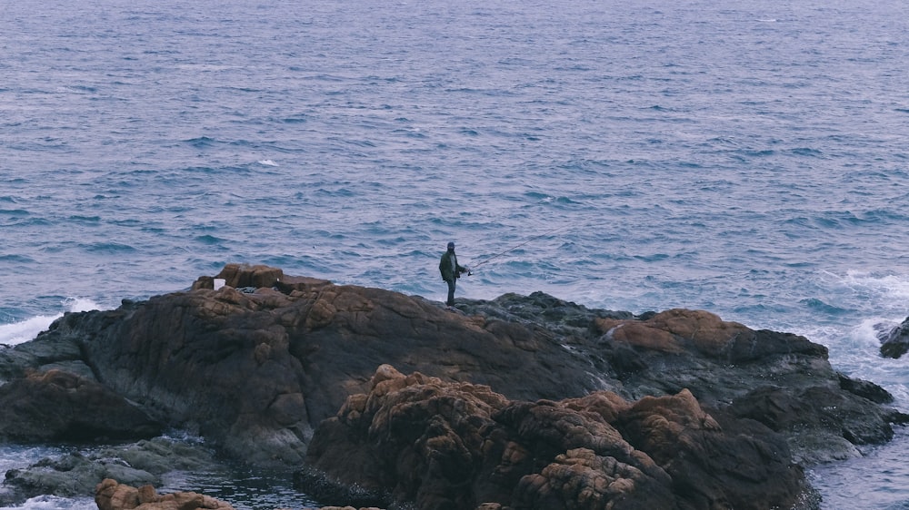 a person standing on a rock in the water