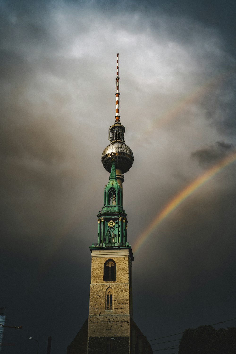 a rainbow over a tall tower