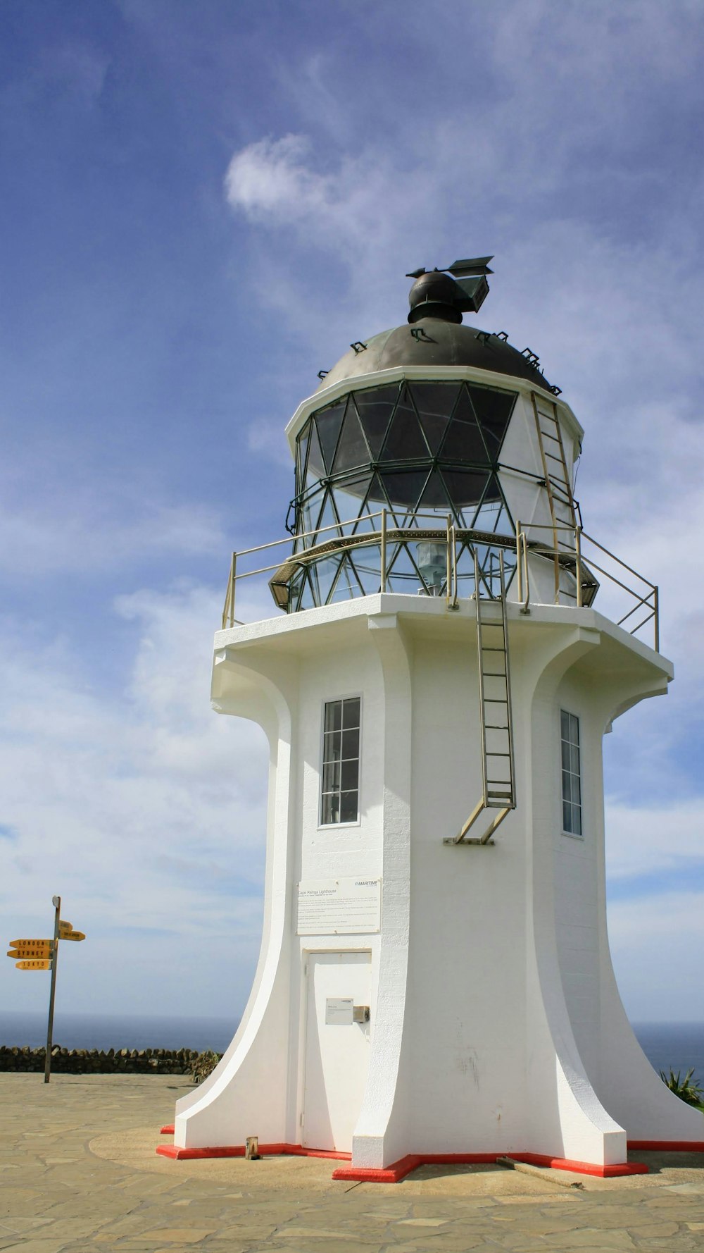 a white lighthouse with a blue sky
