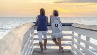 two women walking on a pier