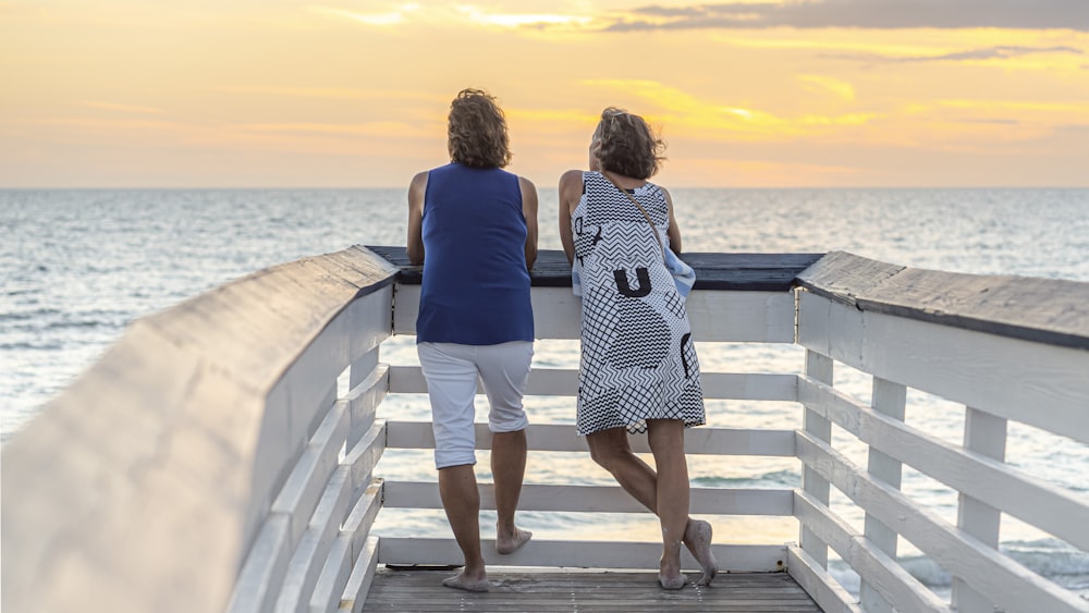 two women walking on a pier