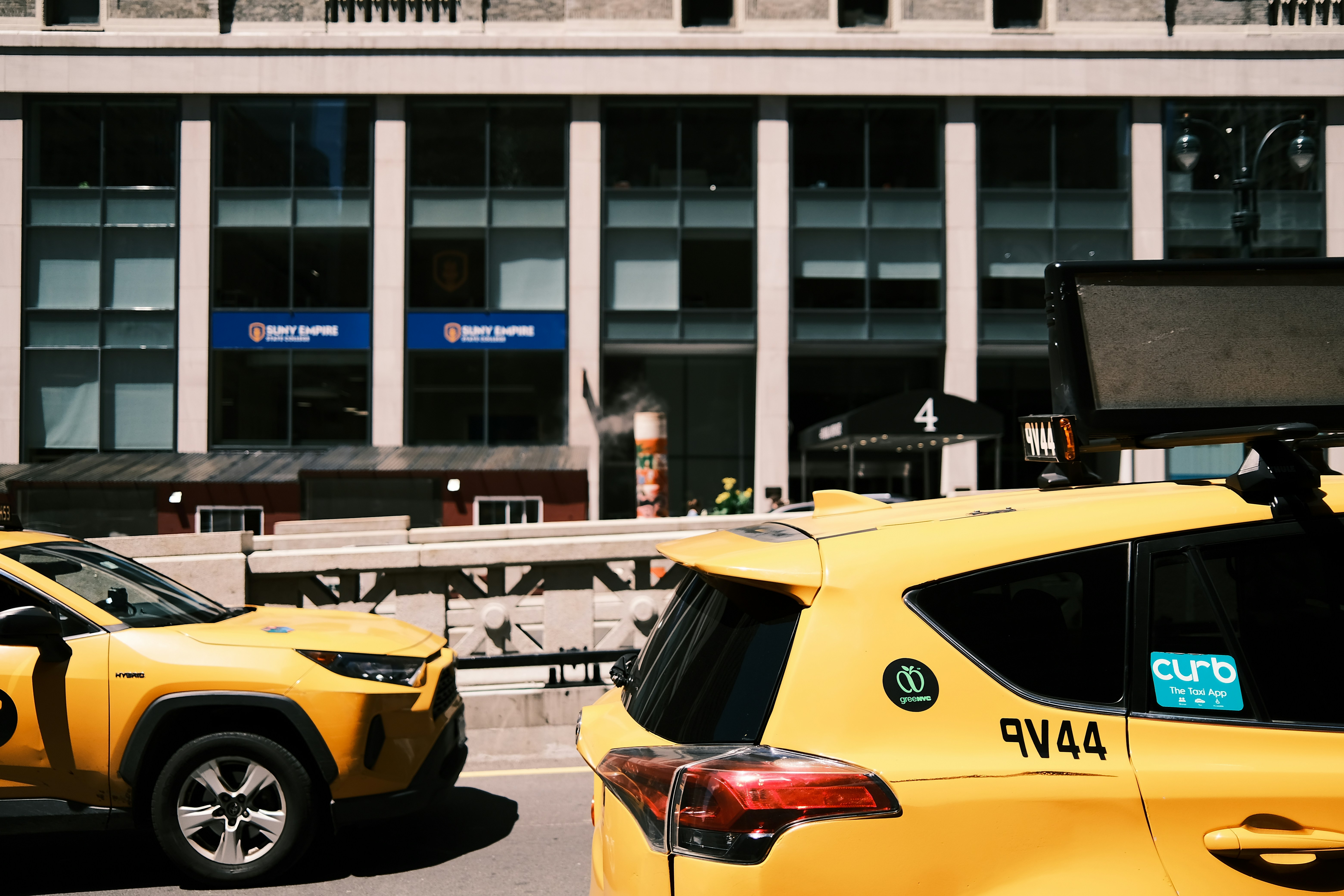 a couple of yellow cars parked in front of a building