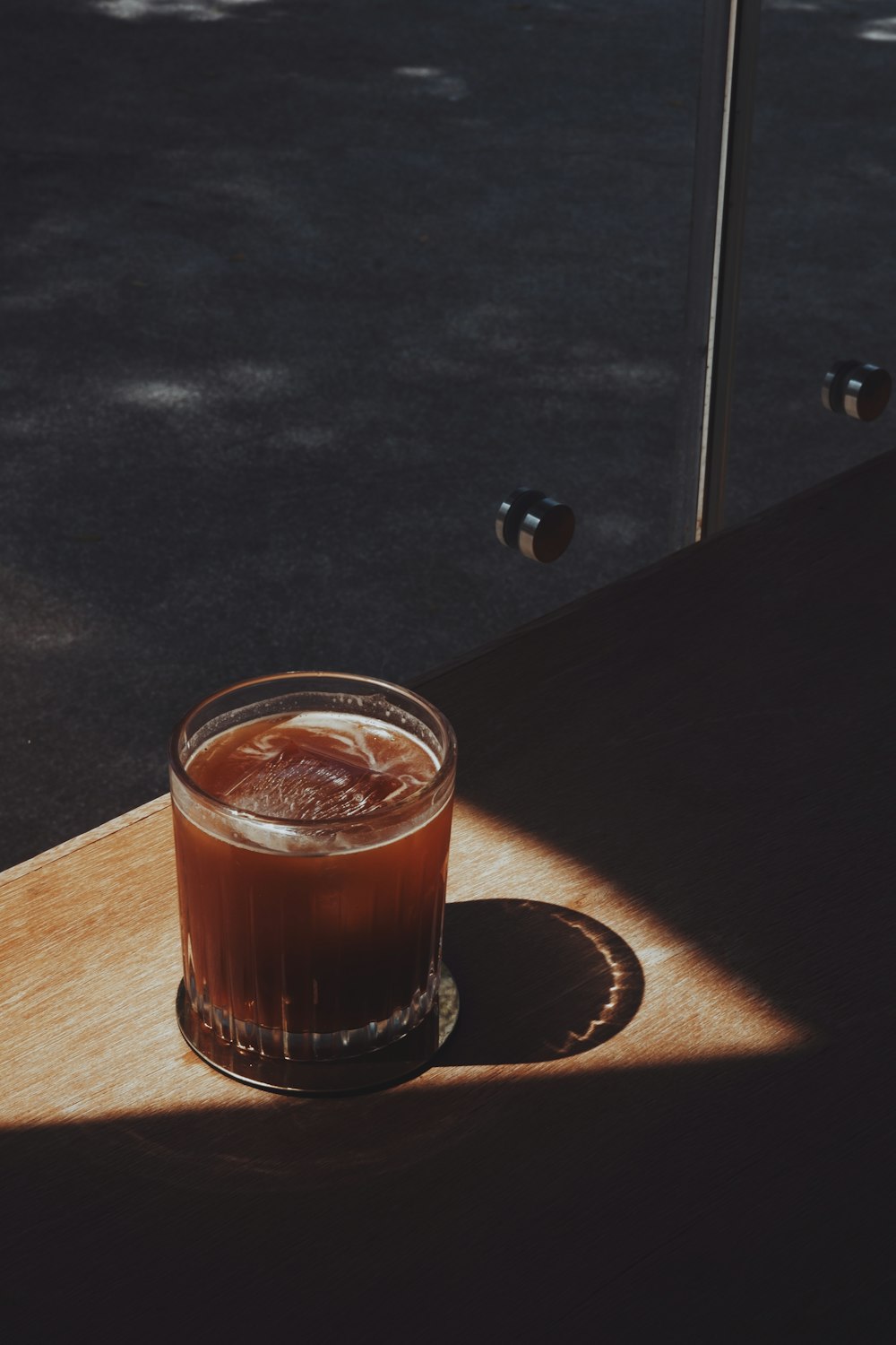 a glass of liquid on a coaster