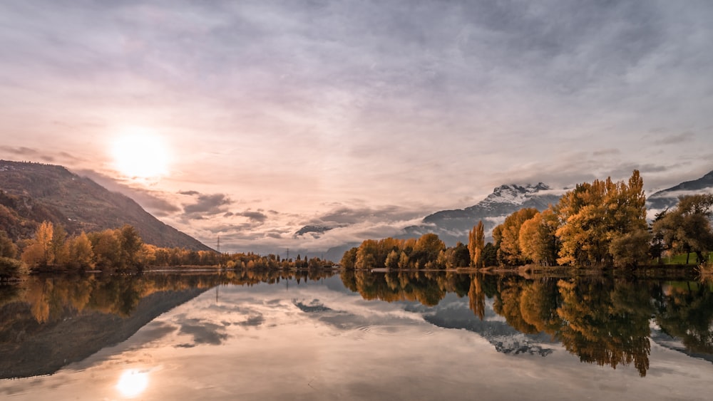 a lake with trees and mountains in the background