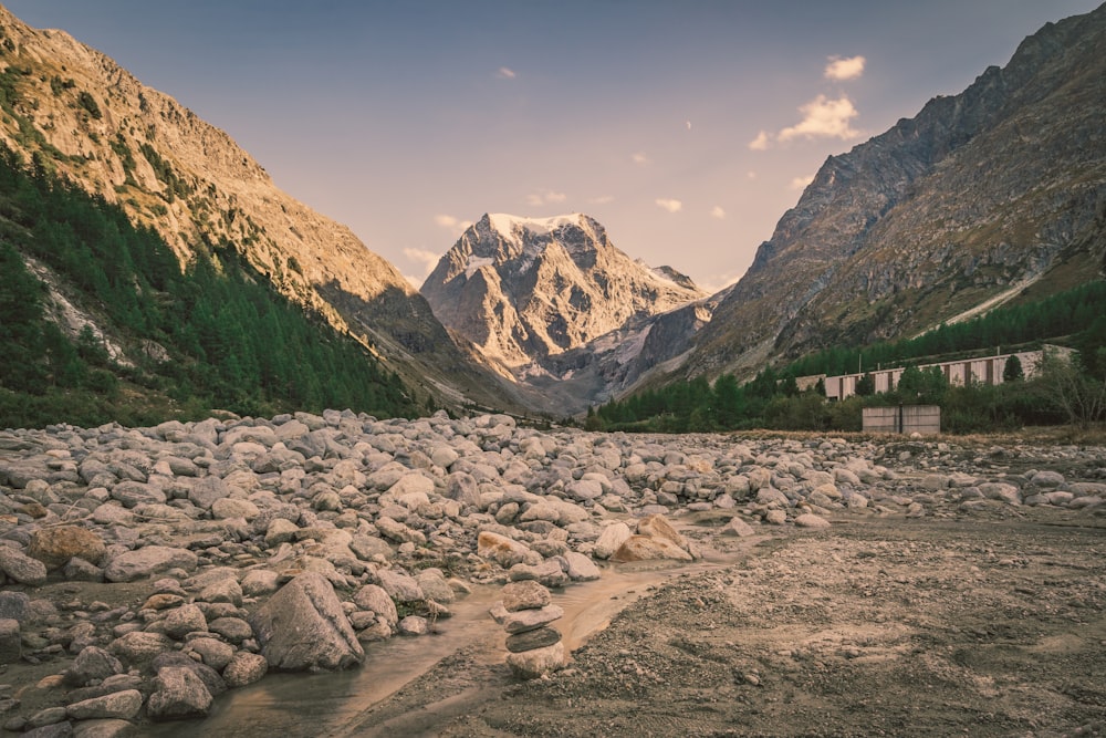 a rocky river bed with mountains in the background