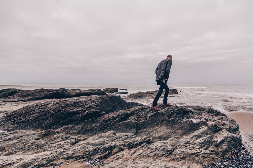 a man standing on a rocky beach