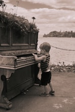 a boy standing next to a boat