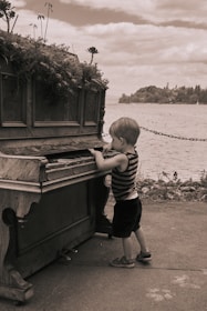 a boy standing next to a boat