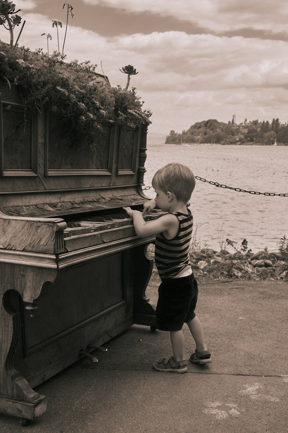 a boy standing next to a boat