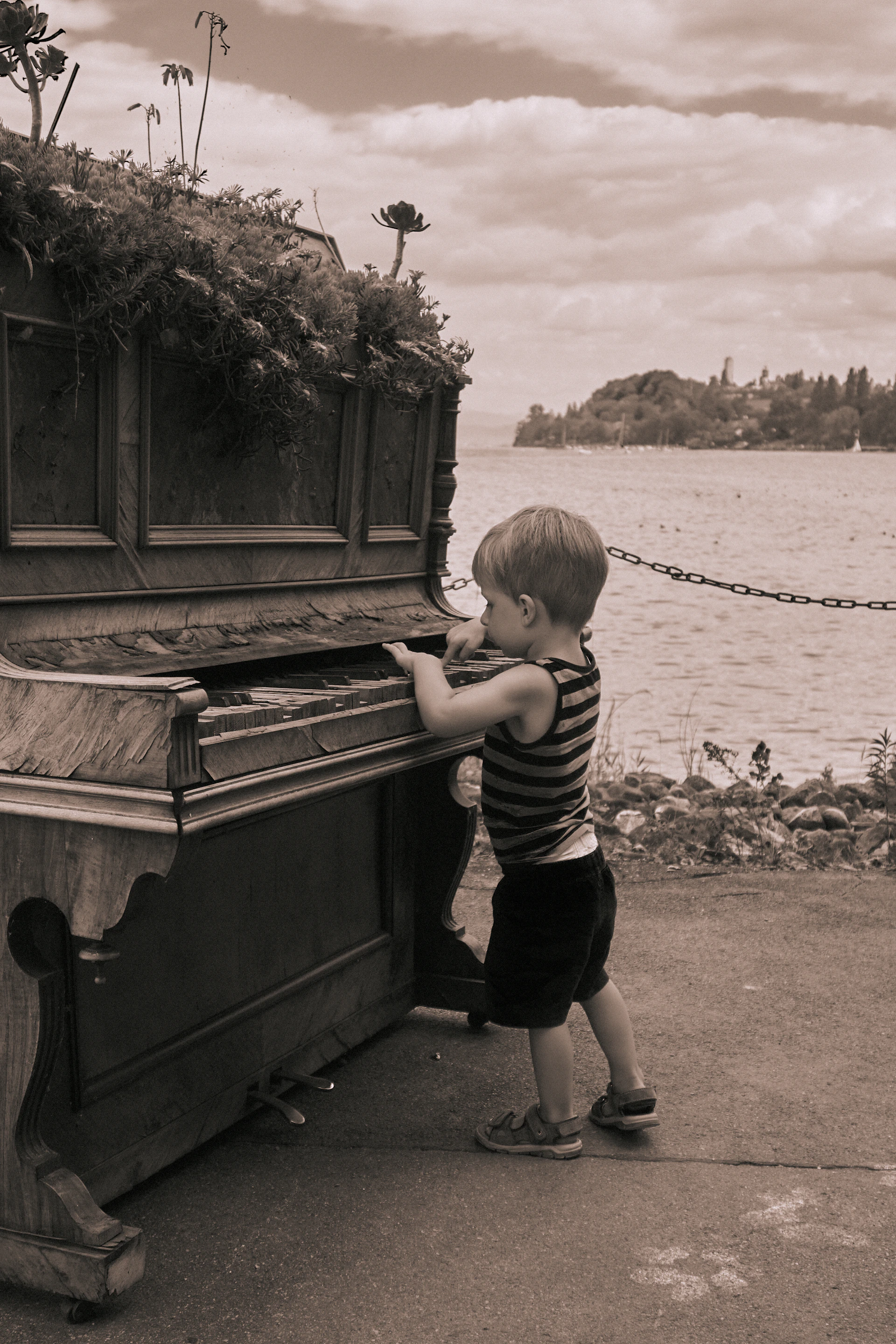 a boy standing next to a boat
