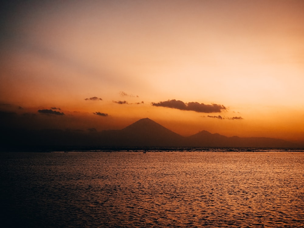 a body of water with a mountain in the distance