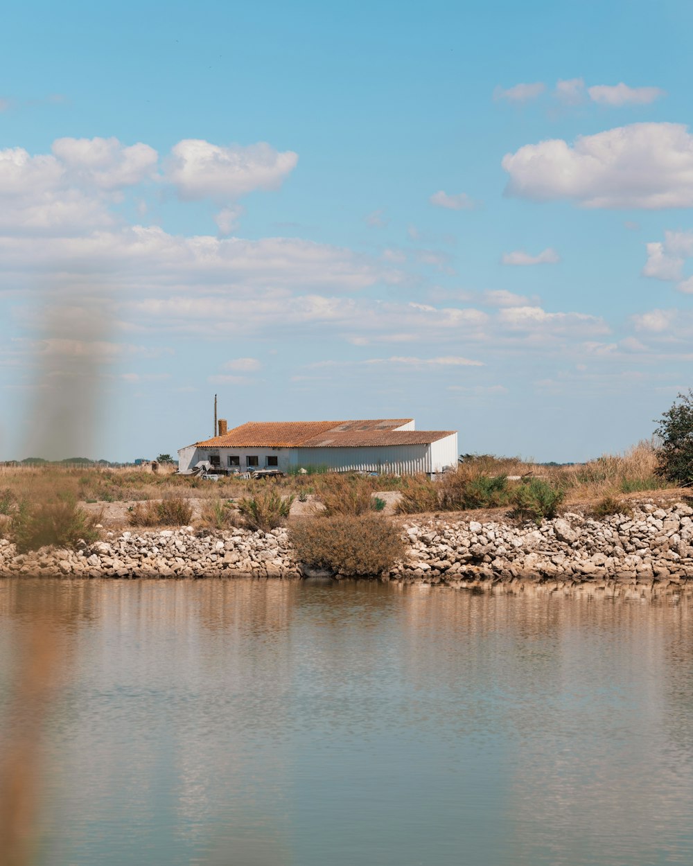 a house on a hill by a body of water