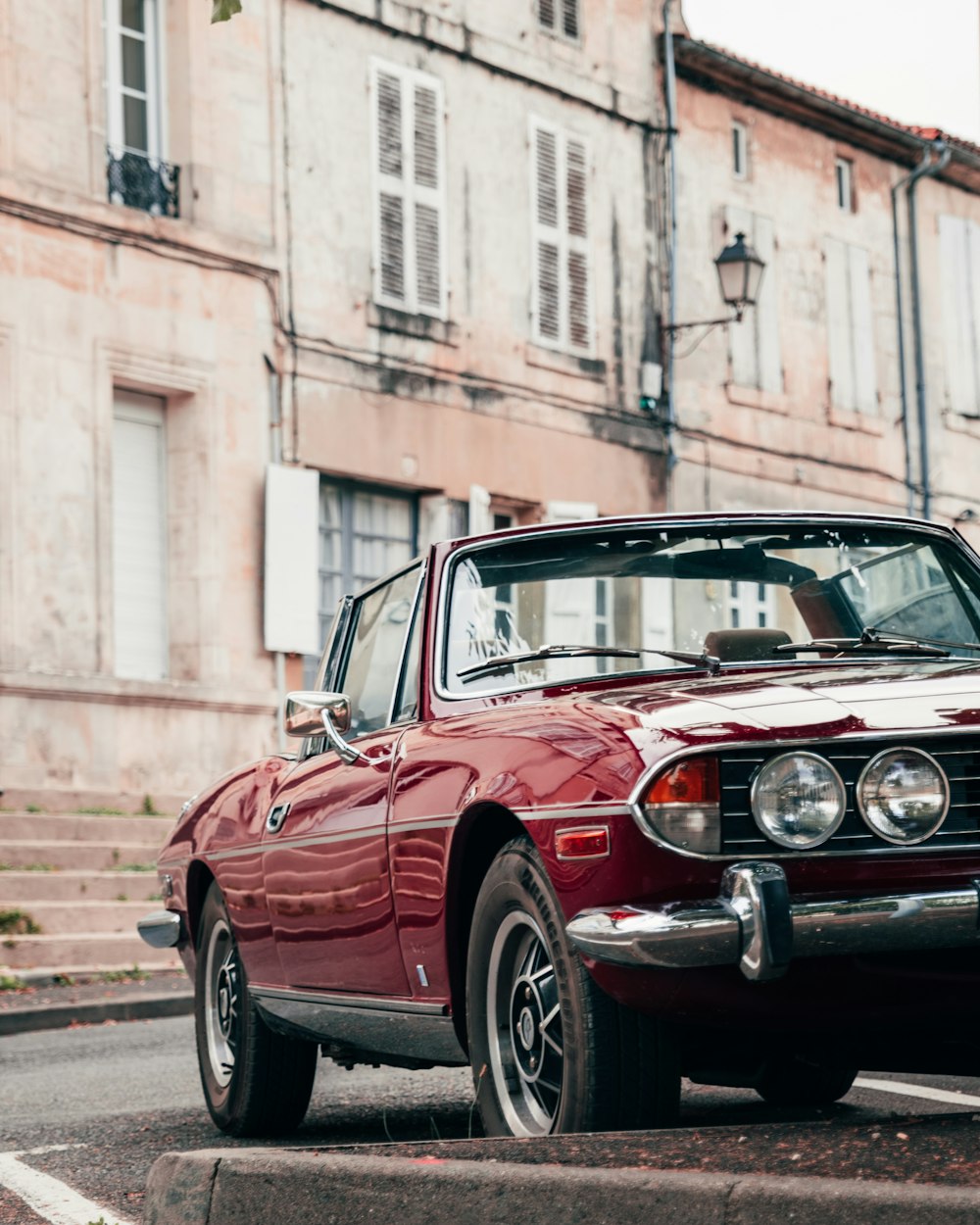 a red car parked on the side of a street