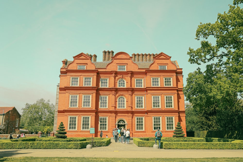 a large building with people walking around with Kew Palace in the background