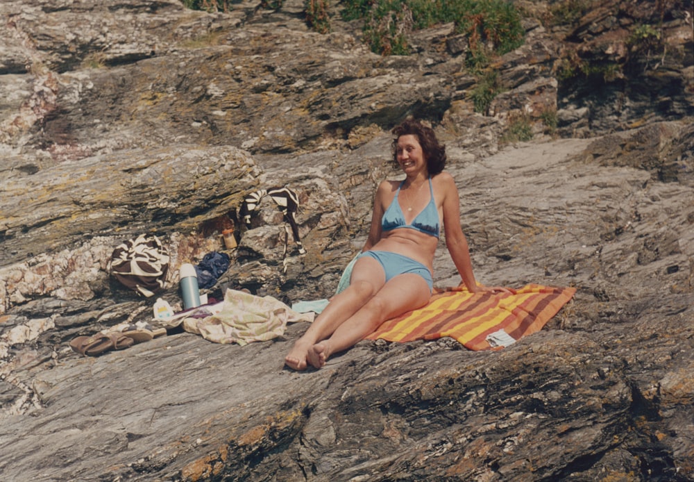 a person sitting on a towel on a beach