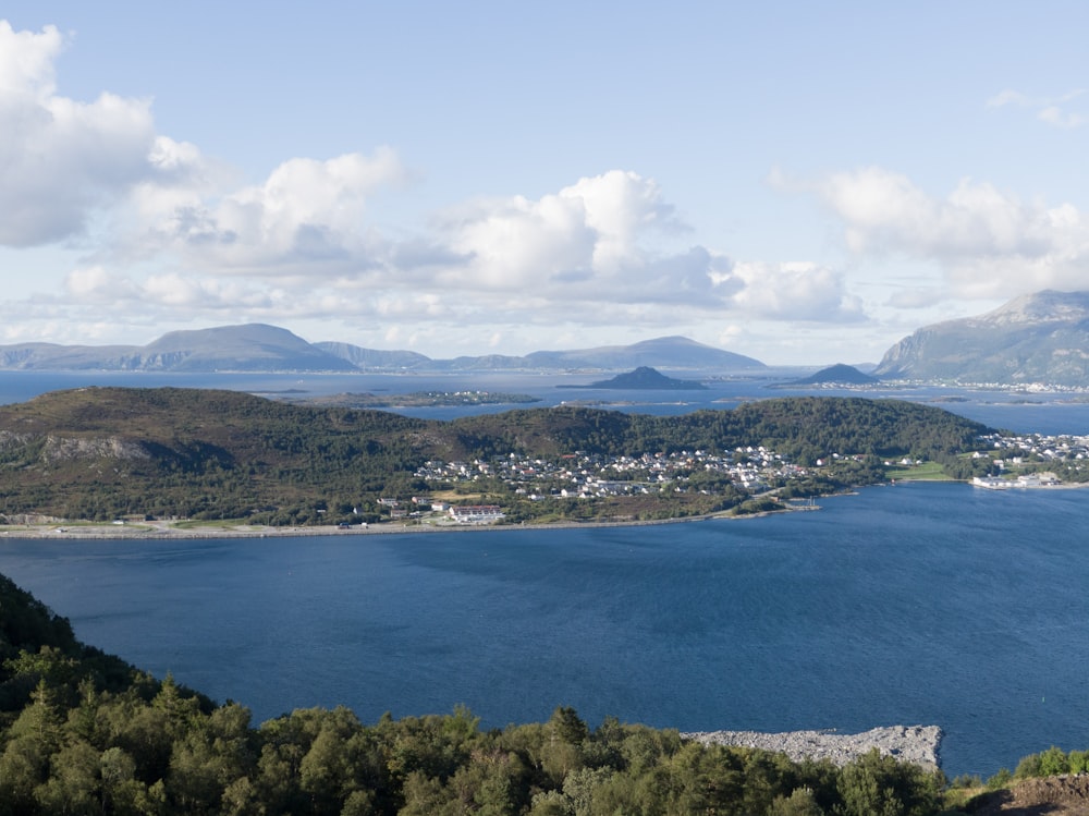 a body of water with trees and mountains in the background