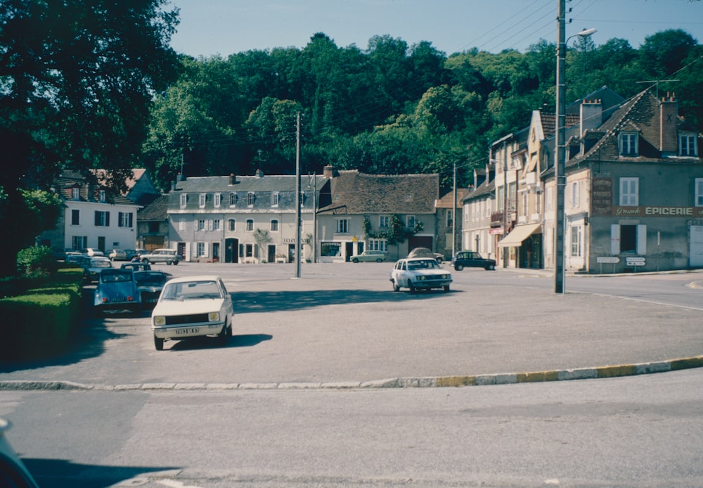 a street with cars parked on the side and houses on the side