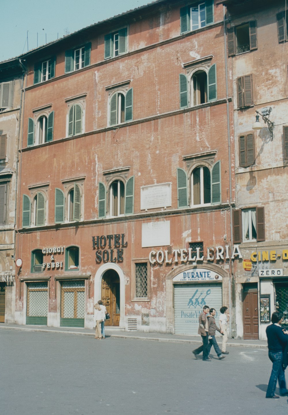 a brick building with people walking in front of it