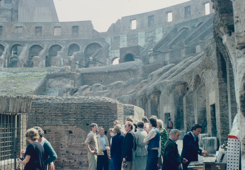 a group of people standing in front of a building that has been destroyed