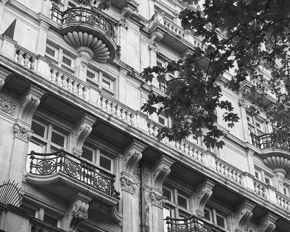 a building with balconies and trees in the front