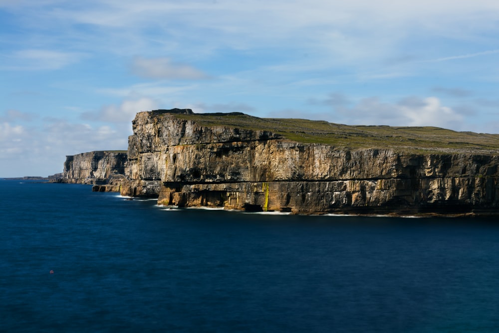 a cliff with a body of water below