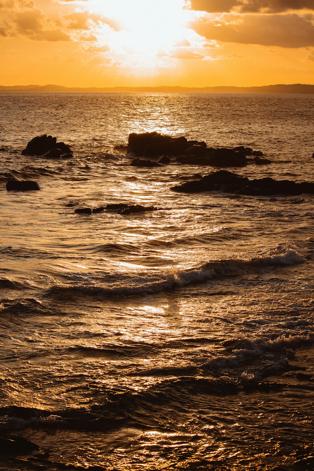 a rocky beach with a sunset