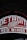 A close-up of a cap featuring the embroidered logo and text of the Detroit Red Wings, with a stylized winged wheel symbol prominently displayed. The words 'Detroit Red Wings' are written in bold white letters on a red background.