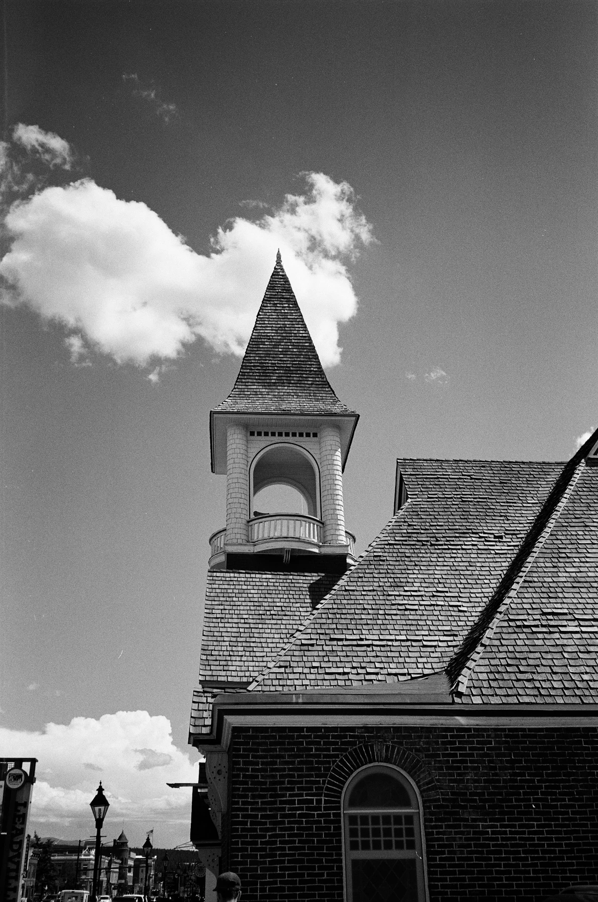 A brick building with a shingled bell tower in Leadville, in black and white