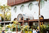 a building with palm trees and people walking by