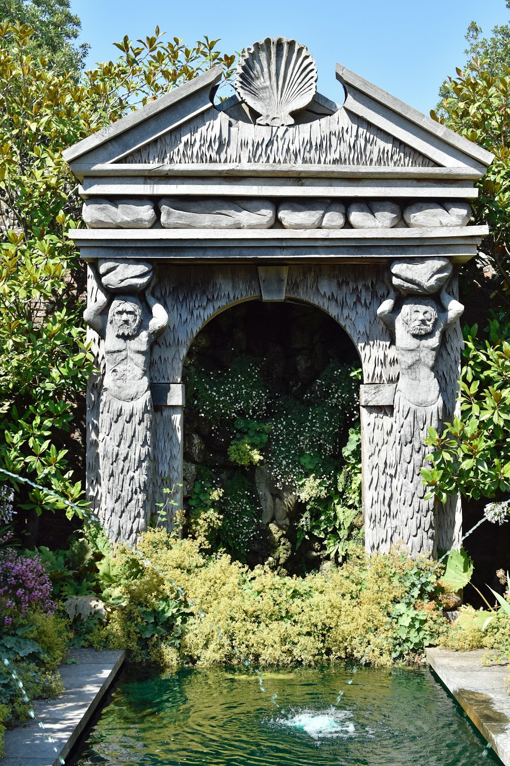 a stone archway over a pond