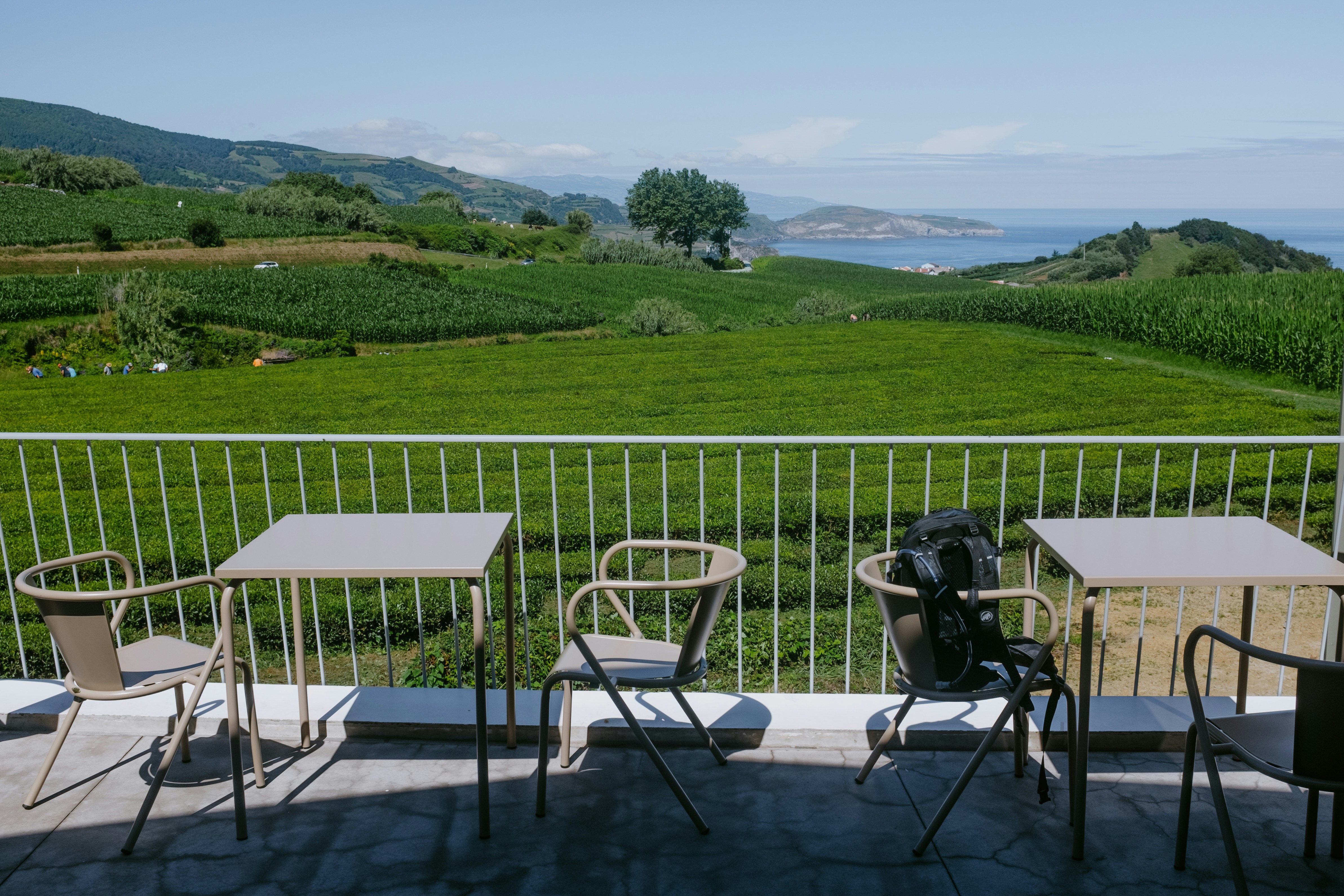 a deck with a table and chairs on it and a field in the background