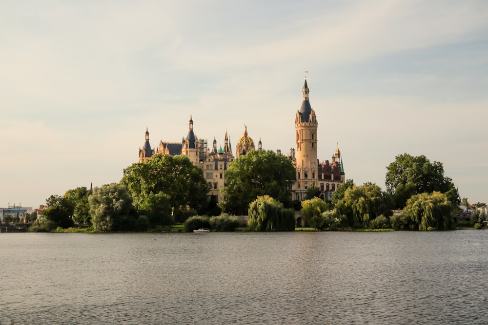 a castle on a hill by a body of water with Schwerin Palace in the background