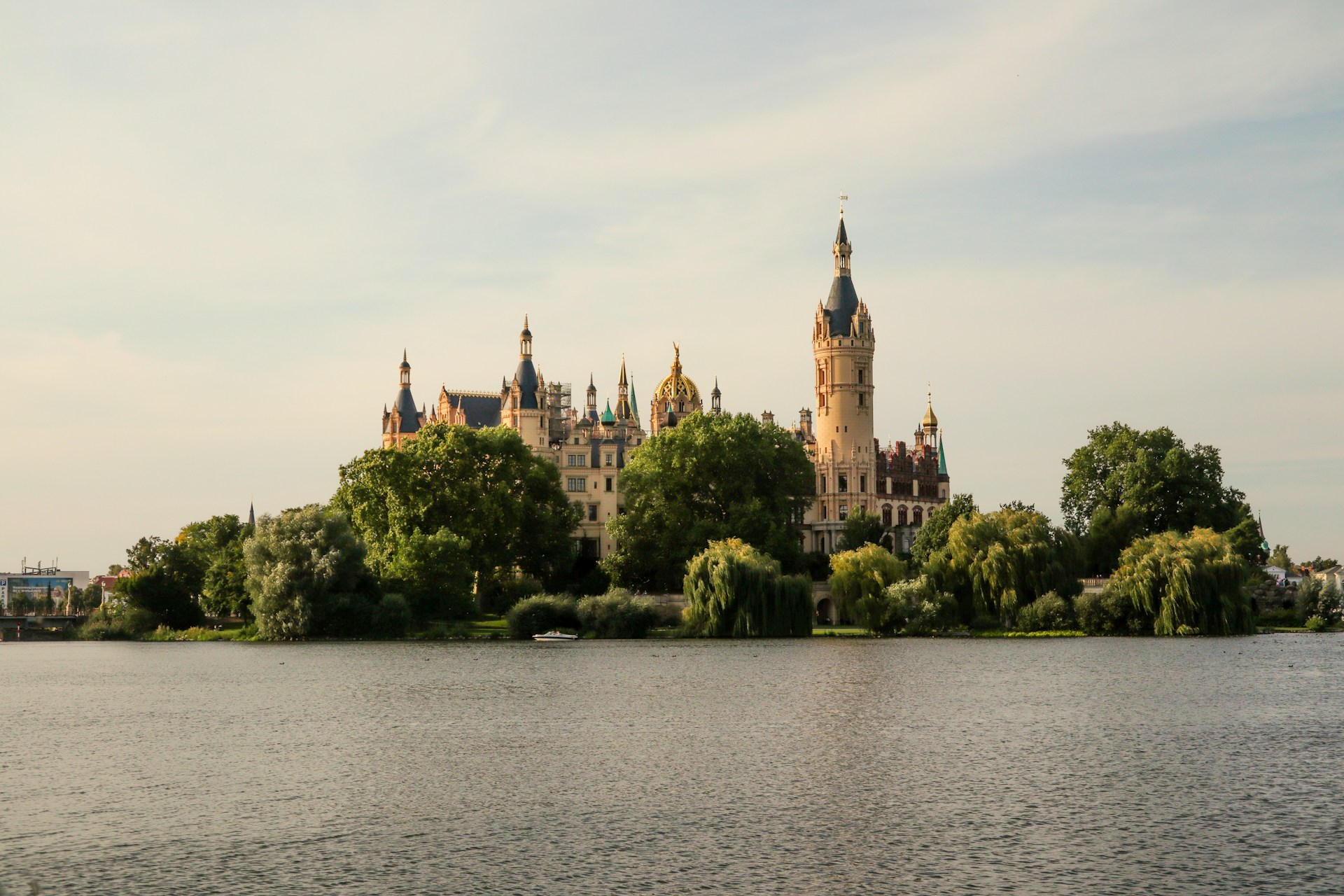 a castle on a hill by a body of water with Schwerin Palace in the background