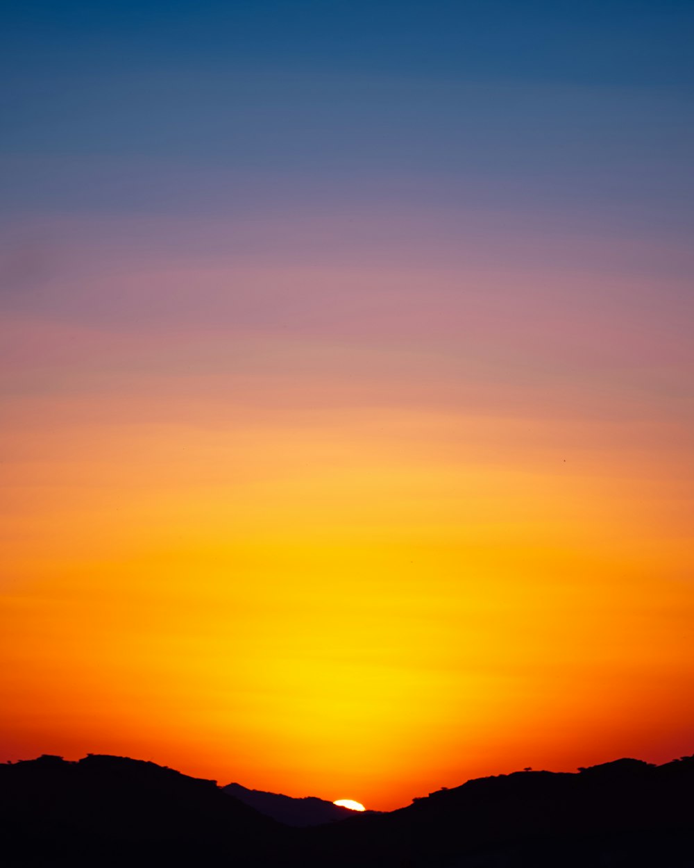 a sunset over a mountain range