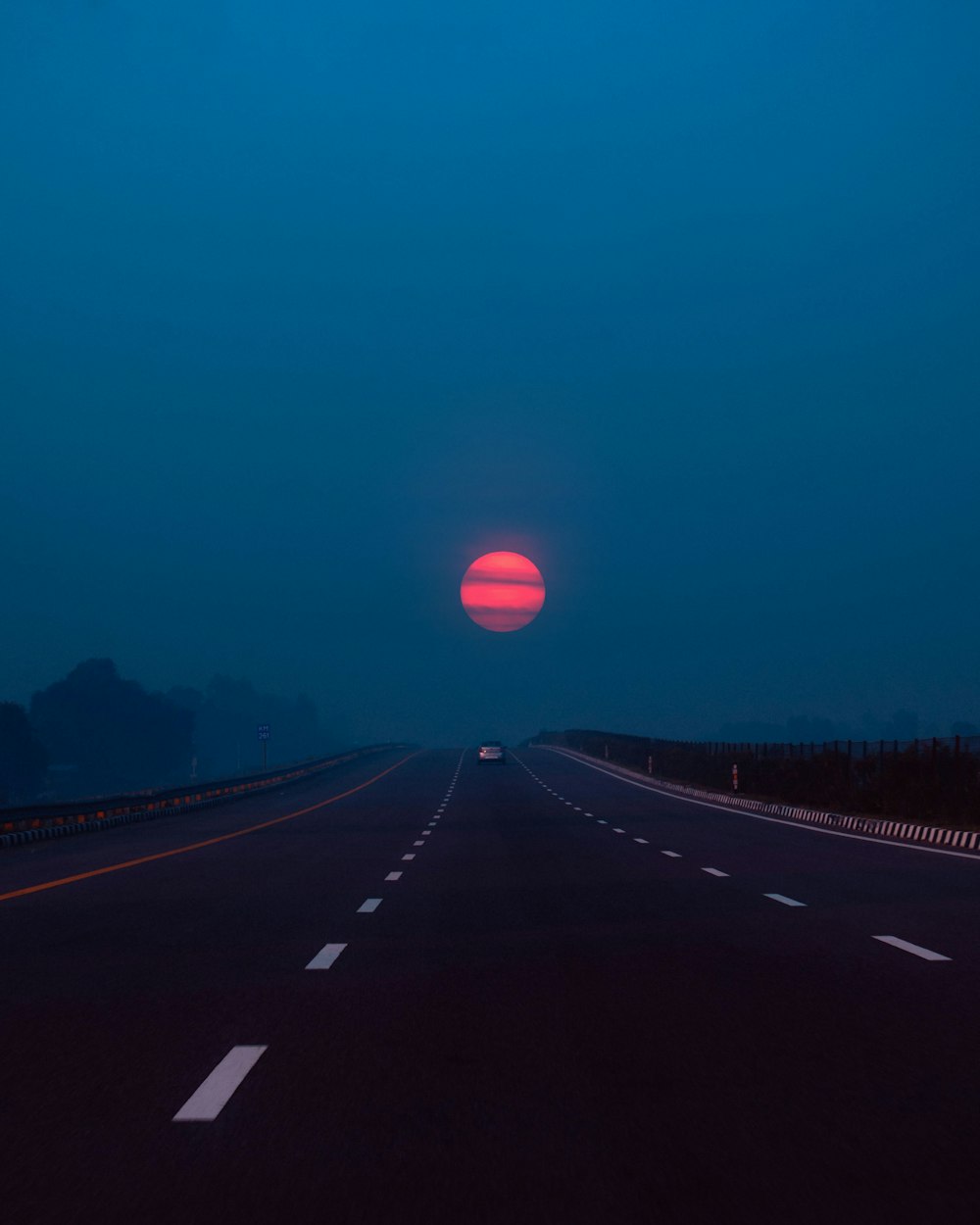a road with a red moon