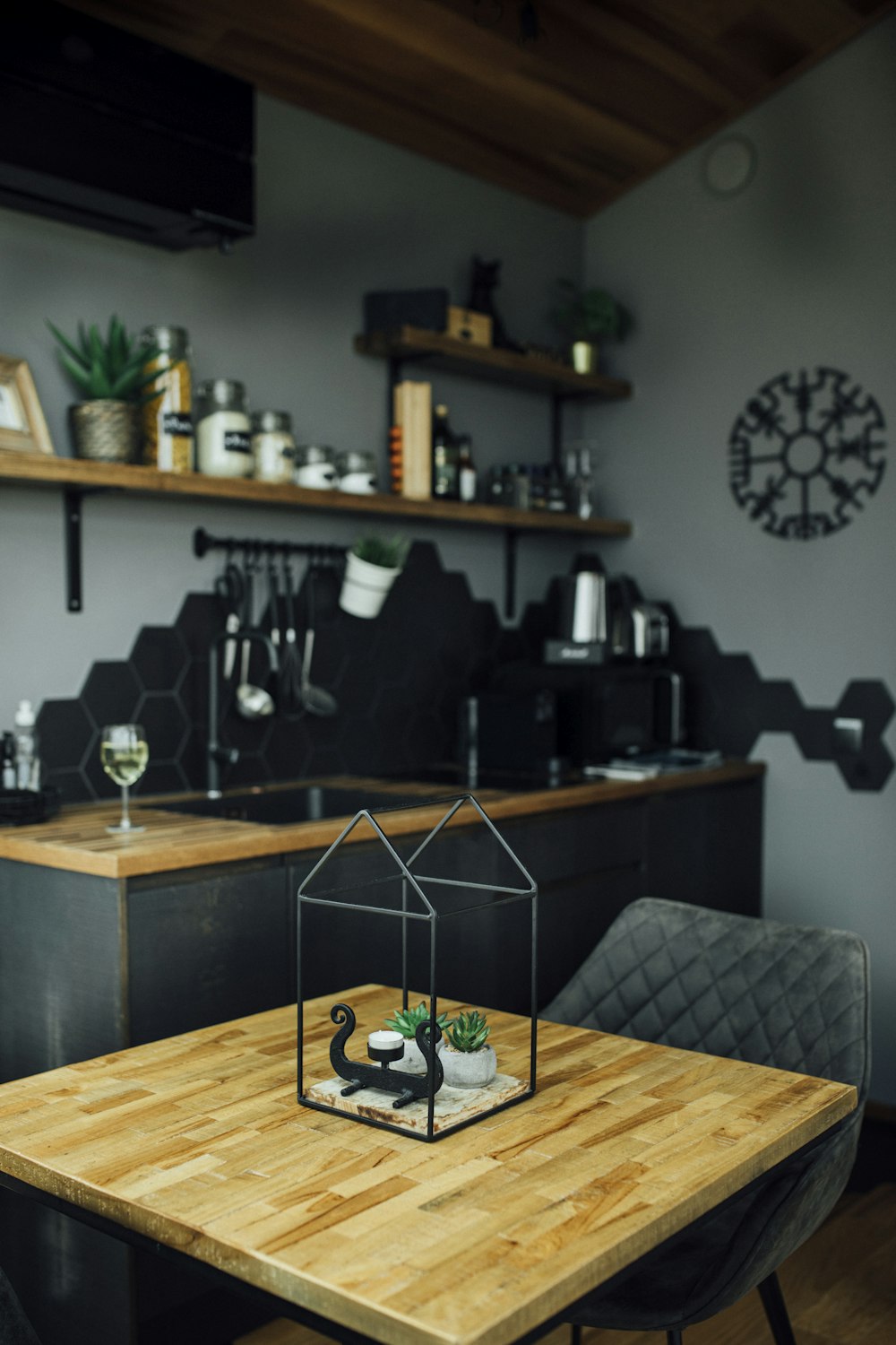 a table with a glass and a shelf with objects on it