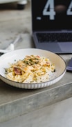 A timer next to a colorful bowl of steaming pasta, highlighting quick preparation.