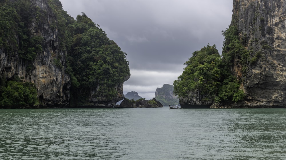 a body of water with trees and rocks on the side