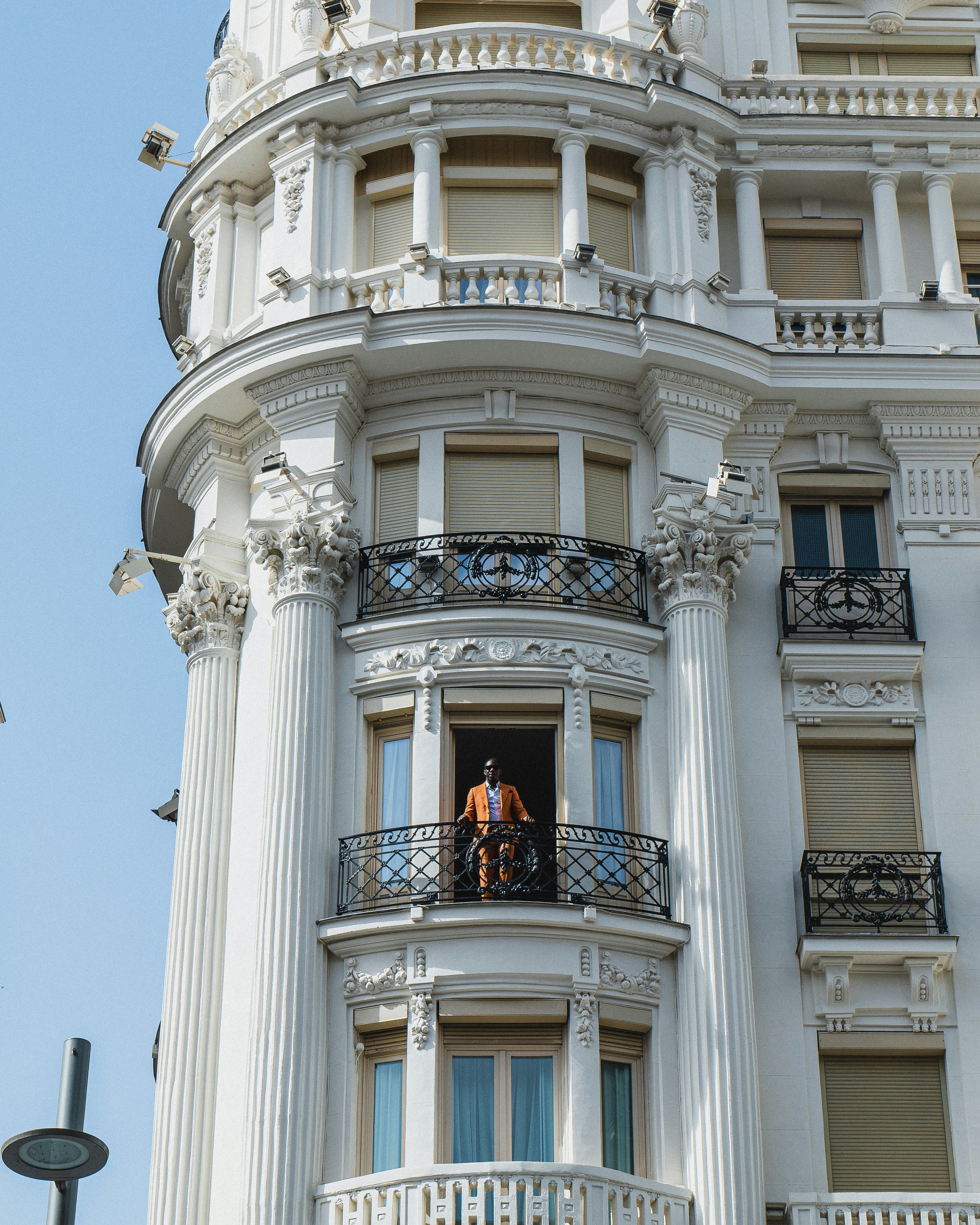 una persona in piedi su un balcone di un edificio