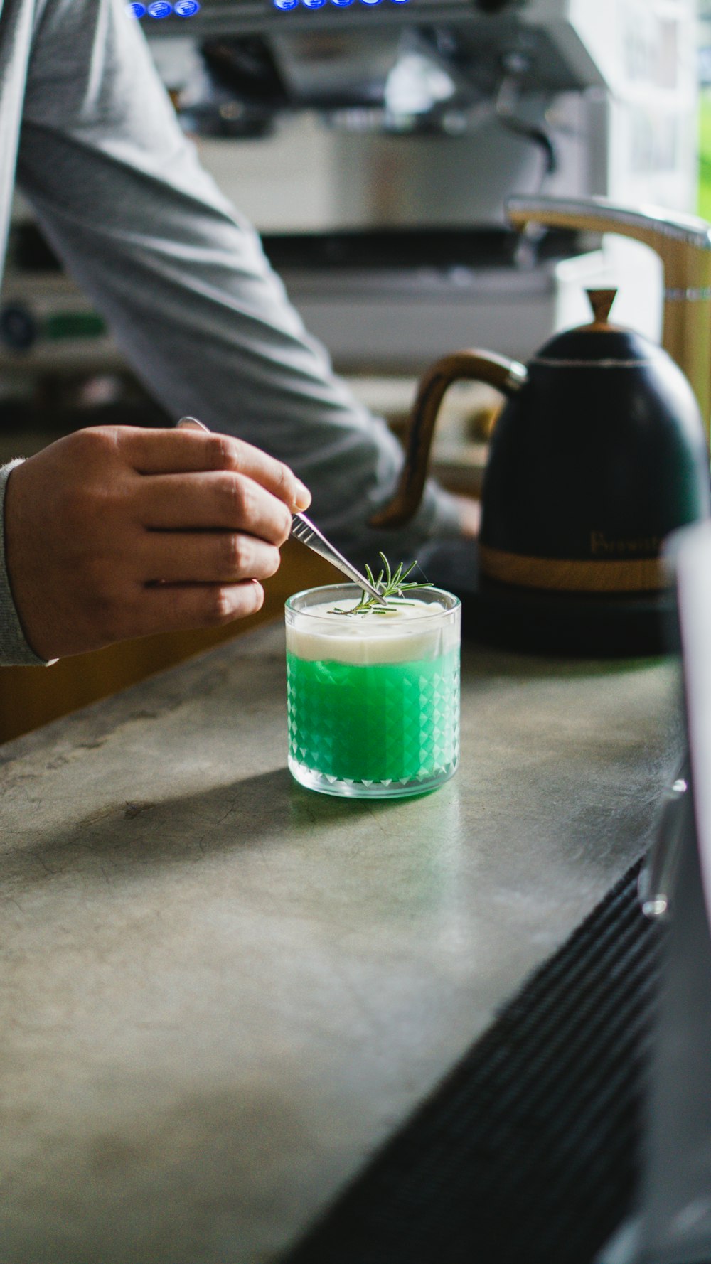 a person holding a green cup with a green substance in it