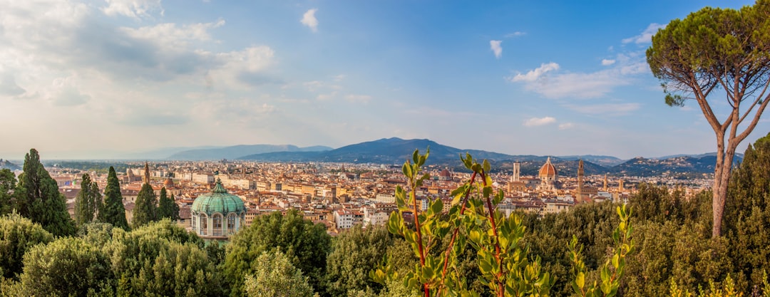 a city with trees and mountains in the background,