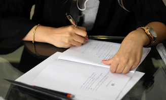 a person writing on a piece of paper
