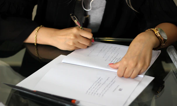 a person writing on a piece of paper